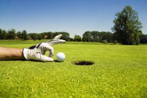 Golfball vor dem einlochen auf dem Golfrasen