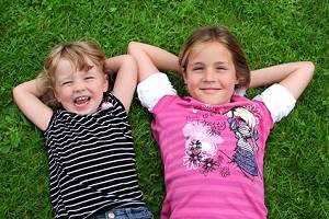 Kinder lachend auf dem Rasen - Rasen anlegen